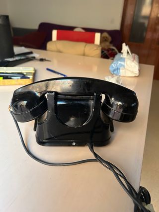 Teléfono antiguo negro y dorado funcionando