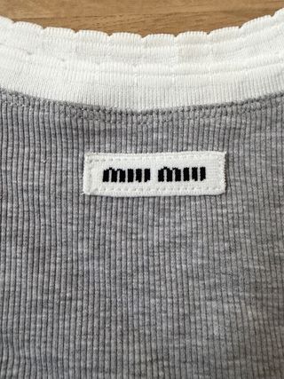 Top Miu gris con ribete blanco.