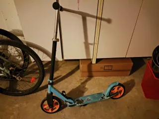 Patinete azul con ruedas naranjas