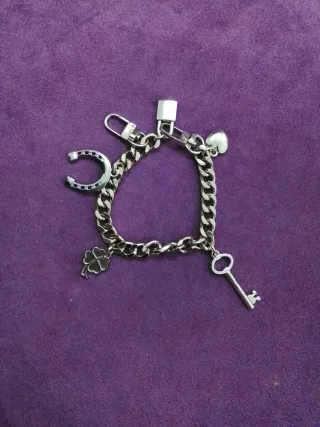 Pulsera plata con charms (candado, llave, trébol,