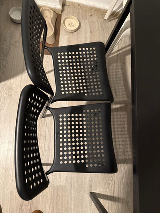 Mesa negra con 4 sillas negras y 3 blancas