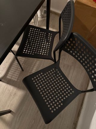 Mesa negra con 4 sillas negras y 3 blancas