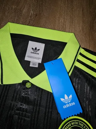 Camiseta Adidas Oasis Gira 2025 Negra y Amarilla