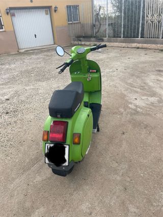 Moto Vespa Verde con Cara Sonriente.