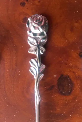 Cubertería de postre con rosa en el mango