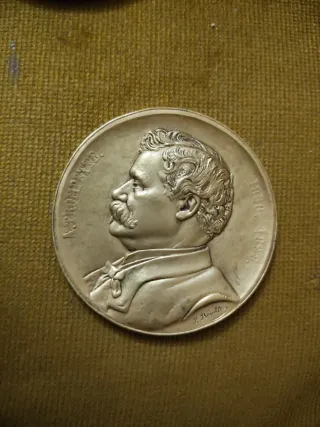 Medalla antigua con retrato y fechas