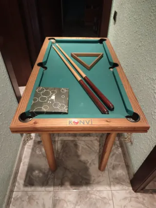 Mesa de billar con tacos y bolas.