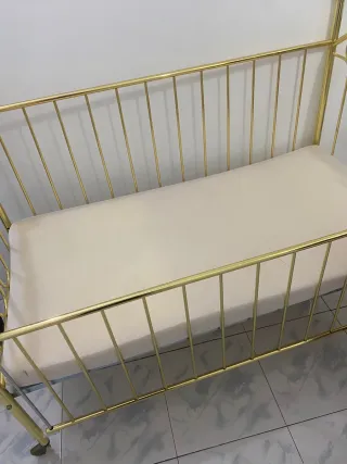Cuna de metal dorada para bebé