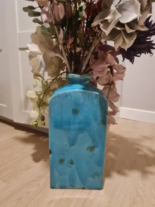 Jarrón azul con flores.