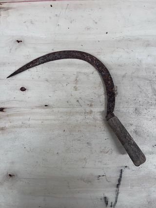 Hoz antigua de metal con mango de madera