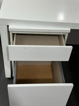 Mesa de escritorio blanca con cajones.