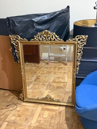 Espejo de pared dorado con marco ornamentado