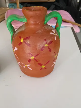 Macetero y pequeños cántaros de arcilla decorados
