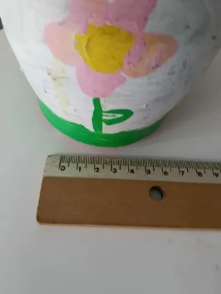 Macetero y pequeños cántaros de arcilla decorados