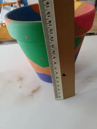 Macetero y pequeños cántaros de arcilla decorados