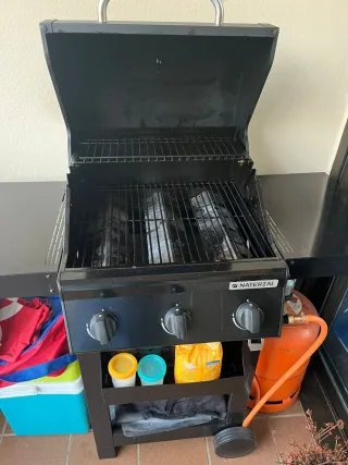 Barbacoa de gas negra con bombona naranja