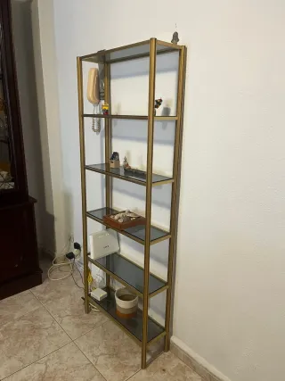 Estantería dorada con baldas de cristal