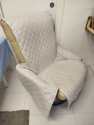 Sillón reclinable de piel beige con funda