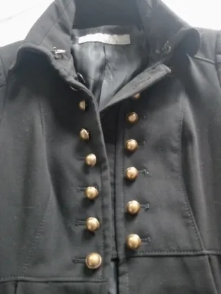 Casaca negra elegante con botones dorados