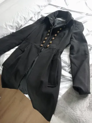 Casaca negra elegante con botones dorados