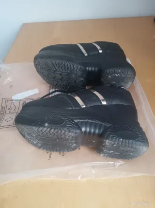 Sapatilhas pretas com sola grossa e detalhes prate