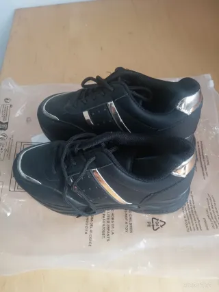 Sapatilhas pretas com sola grossa e detalhes prate