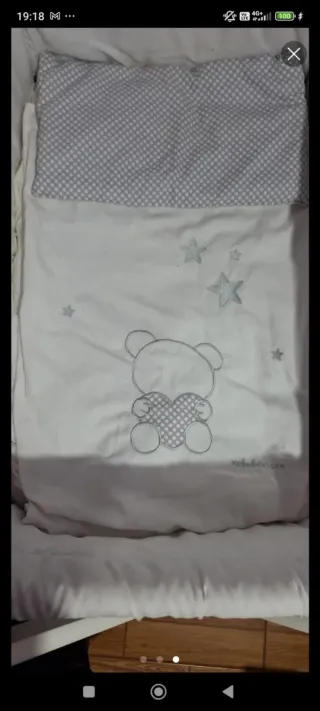 MiniCuna de bebé de madera blanca con ruedas.