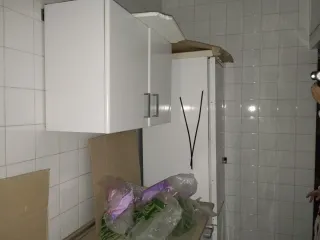 Cocina blanca con tiradores plateados.