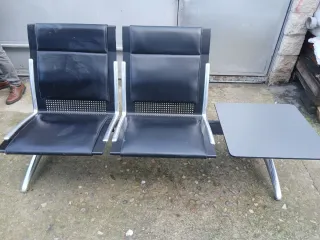 Sillas de espera negras con mesa
