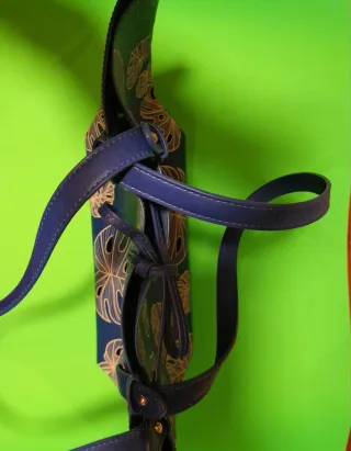 Bolso azul con estampado de hojas.