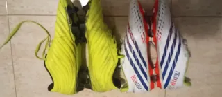 Dos zapatos de fútbol Adidas blancos y amarillos