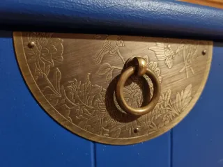 Cajonera azul restaurada con tiradores dorados