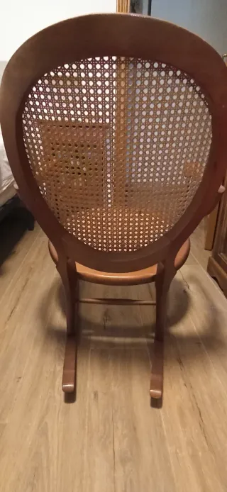 Mecedora pequeña de madera y ratán.