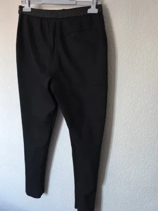 Pantalones negros con cremallera dorada