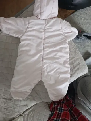 Buzo de bebé rosa con capucha.