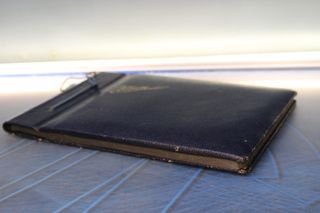 Antiguo álbum fotográfico azul oscuro y dorado.