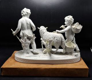 Grande scultura in porcellana Biscuit bianco raffigurante una scena pastorale con due cherubini e pecore