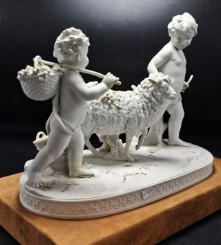 Grande scultura in porcellana Biscuit bianco raffigurante una scena pastorale con due cherubini e pecore