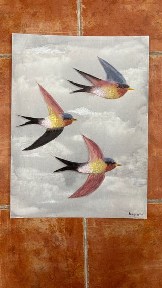 Cuadro de golondrinas volando entre las nubes