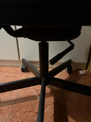 Silla de escritorio negra, con ruedas, giratoria.