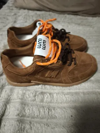 Sapatilha camurça castanha atacadores laranja