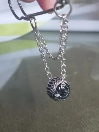 Broche plateado con cadena y cuenta