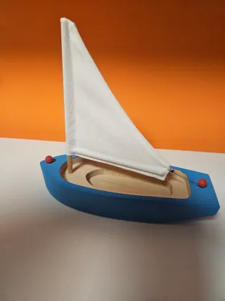 Barco de madera azul con vela blanca
