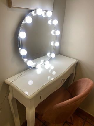 Tocador blanco con espejo con luces y silla rosa