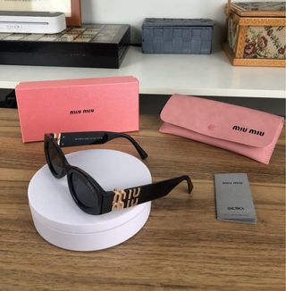Gafas de sol Miu Miu negras y doradas