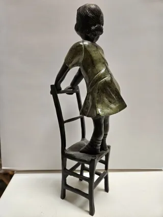 Figura bronce niña en silla