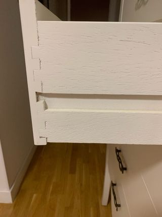 Cómoda alta blanca con tiradores dorados