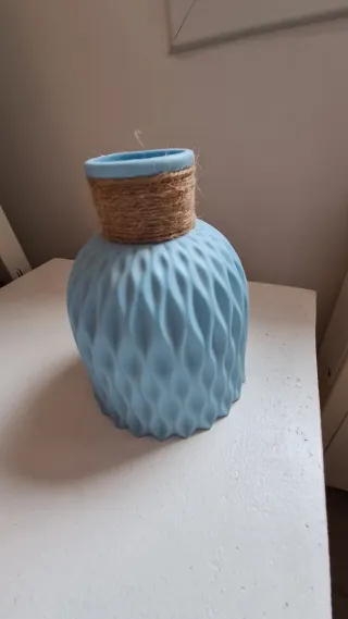 Jarrón azul con plumas decorativas