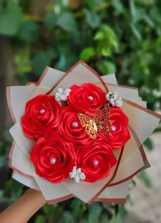 Ramo de rosas rojas con mariposa dorada
