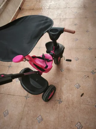 Triciclo rosa con manillar y capota